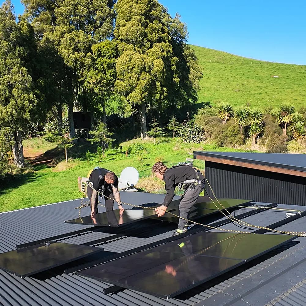 Two EFS Solar installers fitting panels on a 9.1kW system at a rural home in Raglan, Waikato