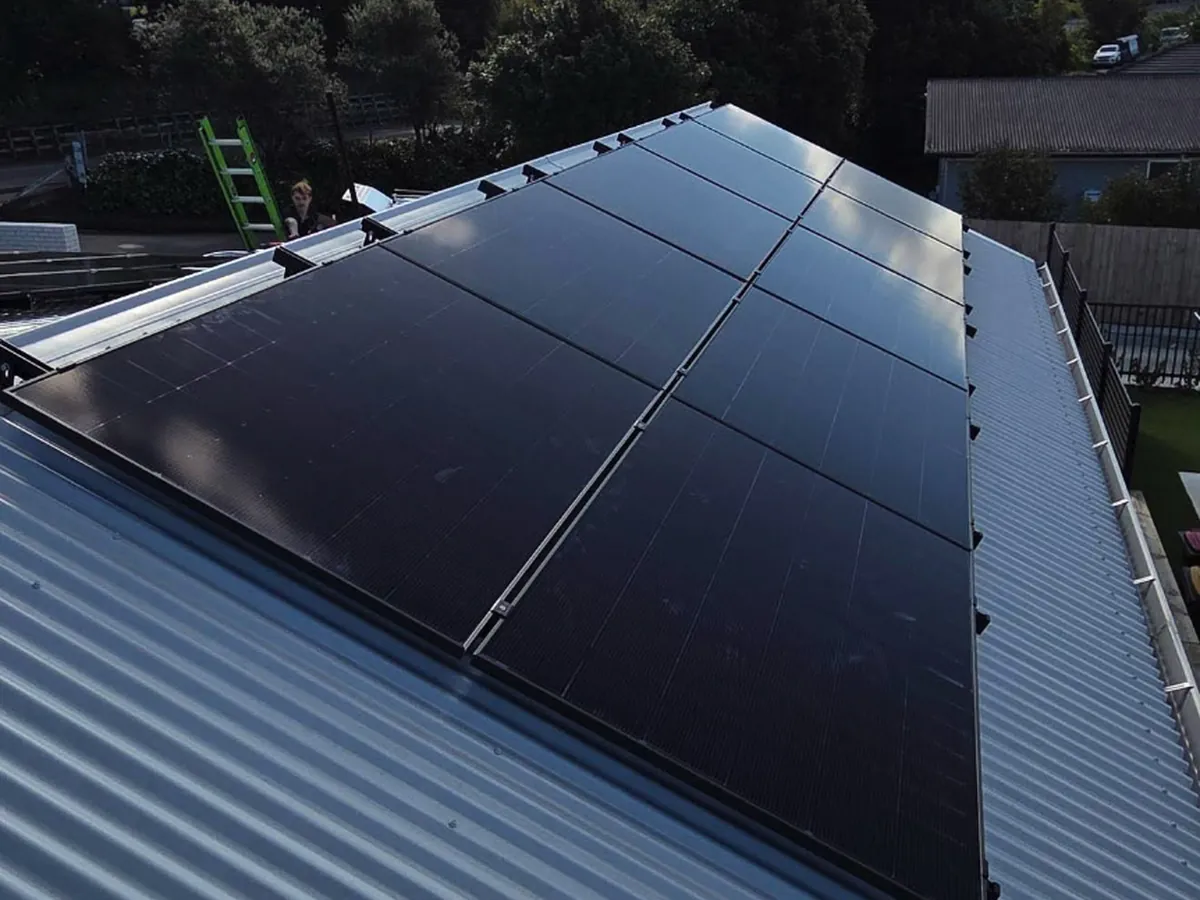 A 10.1kW EFS Solar array on a silver metal roof in Hamilton, Waikato, on a suburban hillside