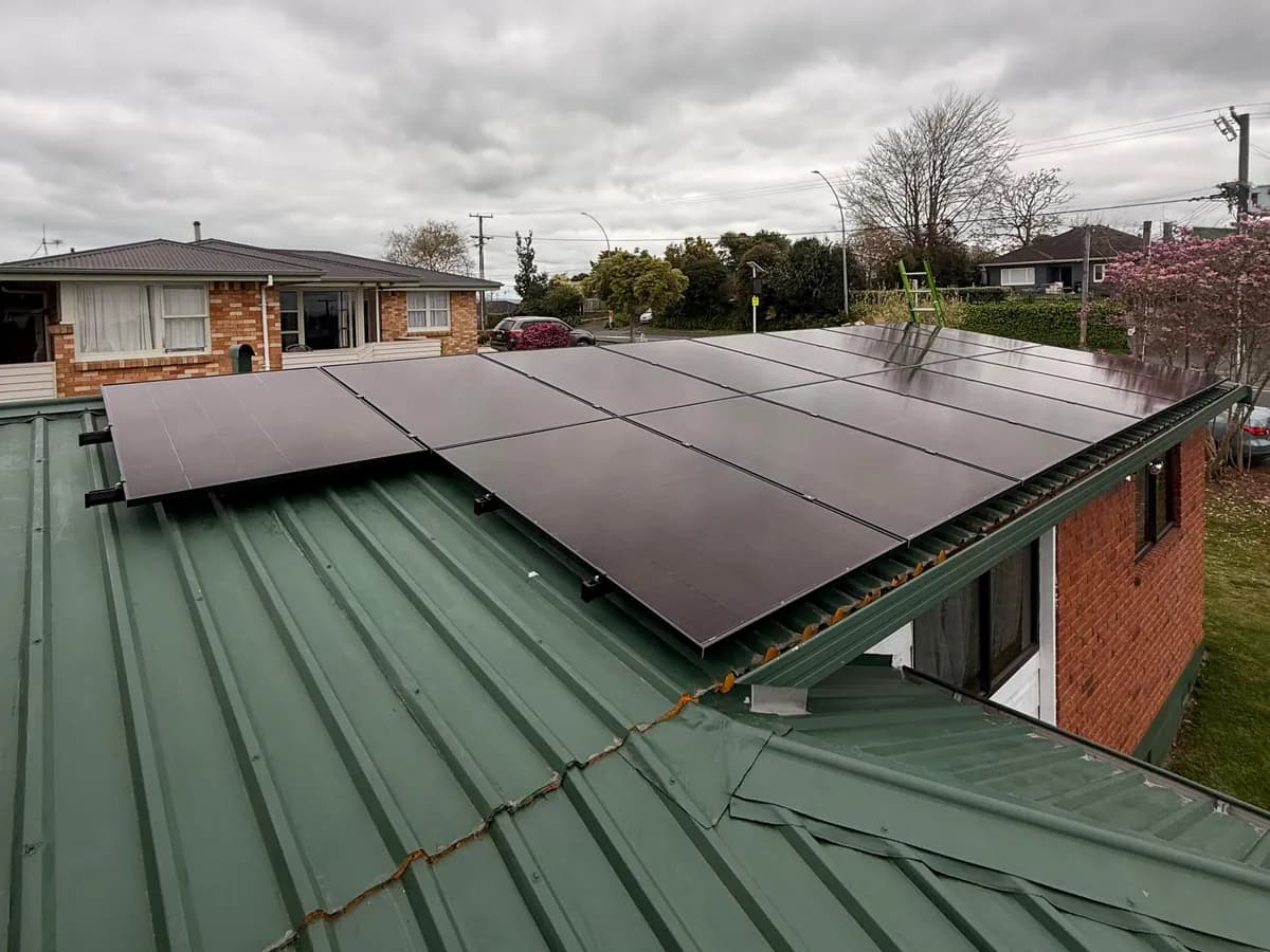 A 6.83kW EFS Solar array on a green metal roof at a brick home in Hamilton, Waikato