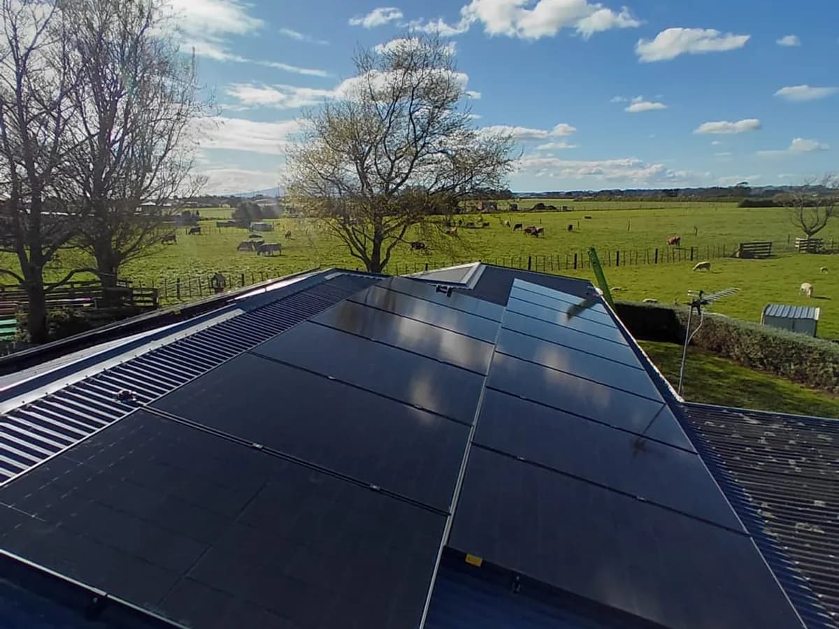A 9.1kW EFS Solar array on a charcoal roof at a rural Hāwera home, Taranaki, paddocks behind