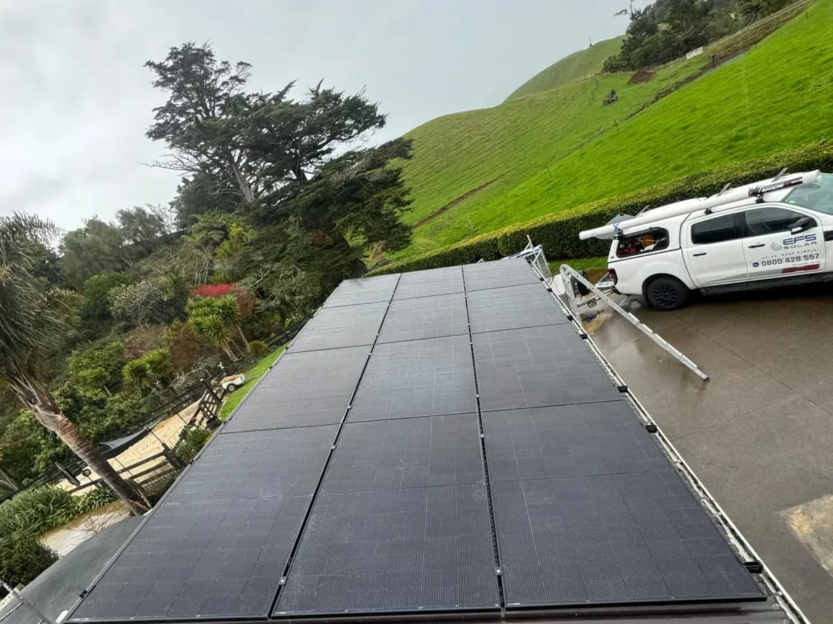 A 5.46kW EFS Solar array on a rural roof at Hurford, Taranaki, green hills behind
