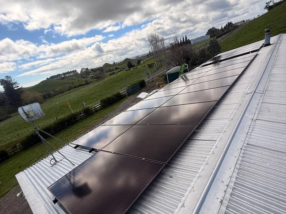 A 10.47kW EFS Solar array on a silver corrugated roof at a rural Inglewood property, Taranaki, with hills behind