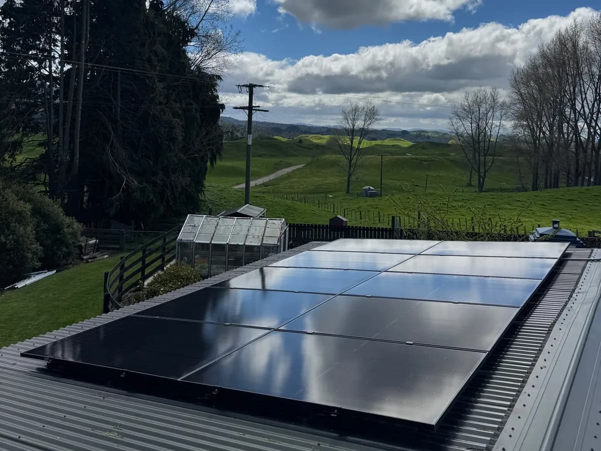 A 9.1kW EFS Solar array on a metal roof at a rural Marotiri property, Waikato, with rolling green hills behind