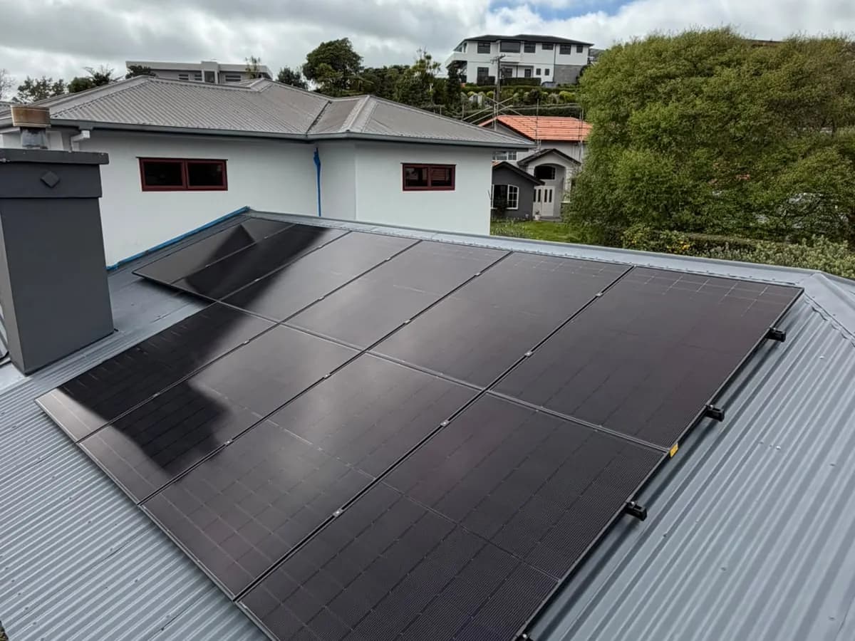 A 6.83kW EFS Solar array in two sections on a charcoal roof at a white weatherboard home in New Plymouth, Taranaki