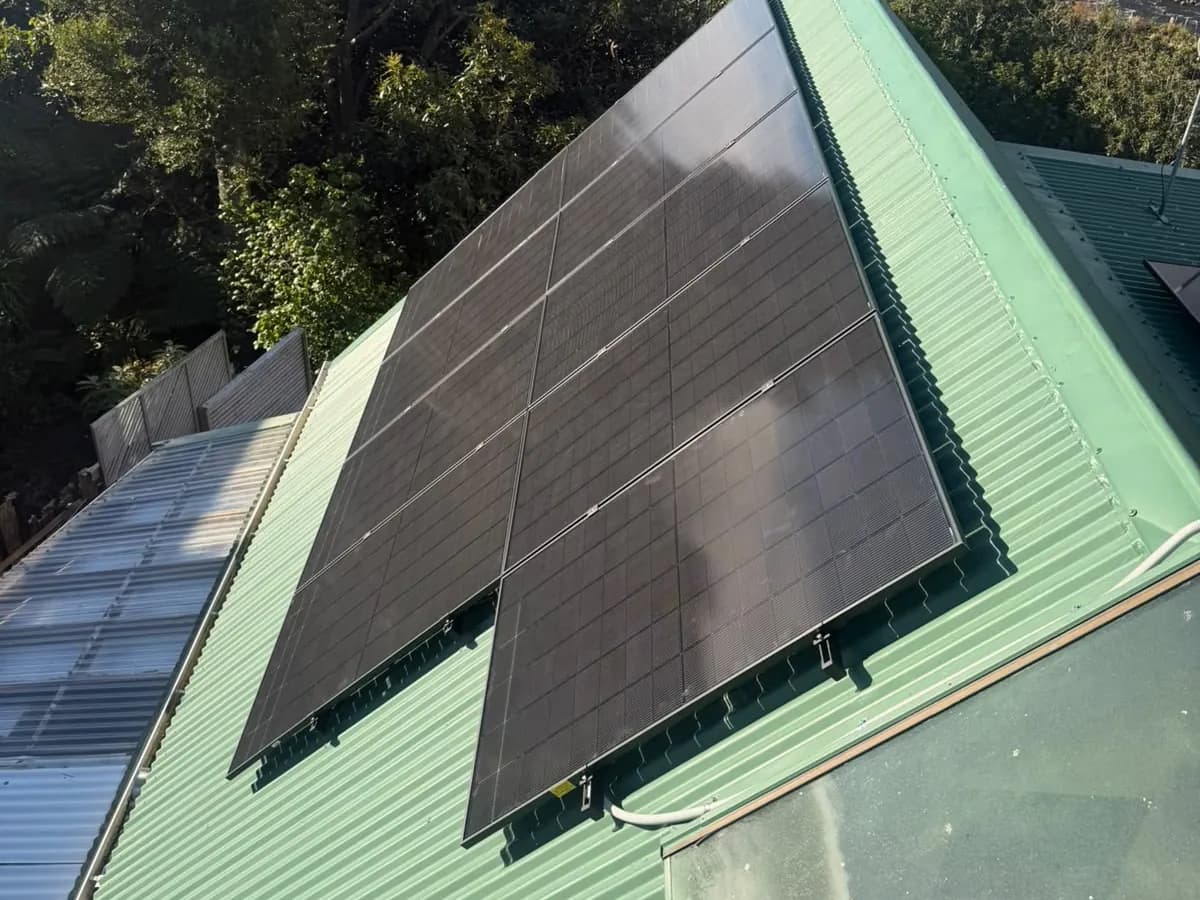 A 6.83kW EFS Solar array on a green roof in New Plymouth, Taranaki, bush behind