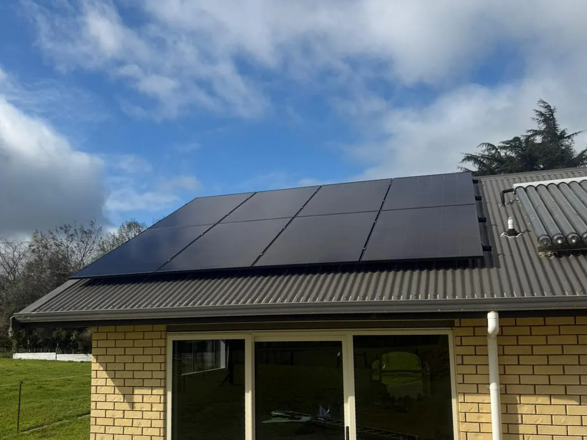 A 9.1kW EFS Solar array on the roof of a brick home at Tamahere, Waikato, paddocks behind