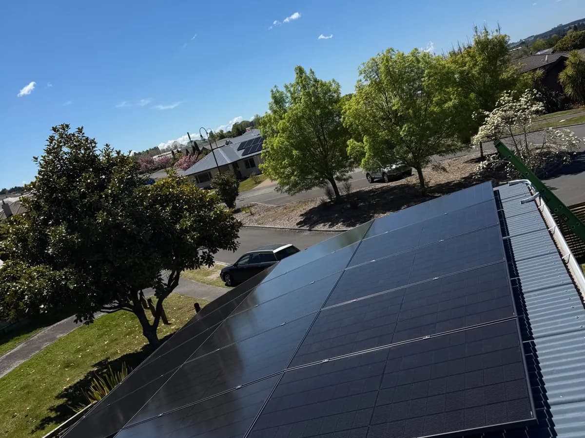 A 6.37kW EFS Solar array on a metal roof in Taupō, Waikato, with trees and a driveway behind
